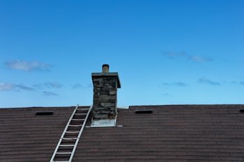 Chimney with a ladder set up for service, similar to homes throughout Hendersonville, TN